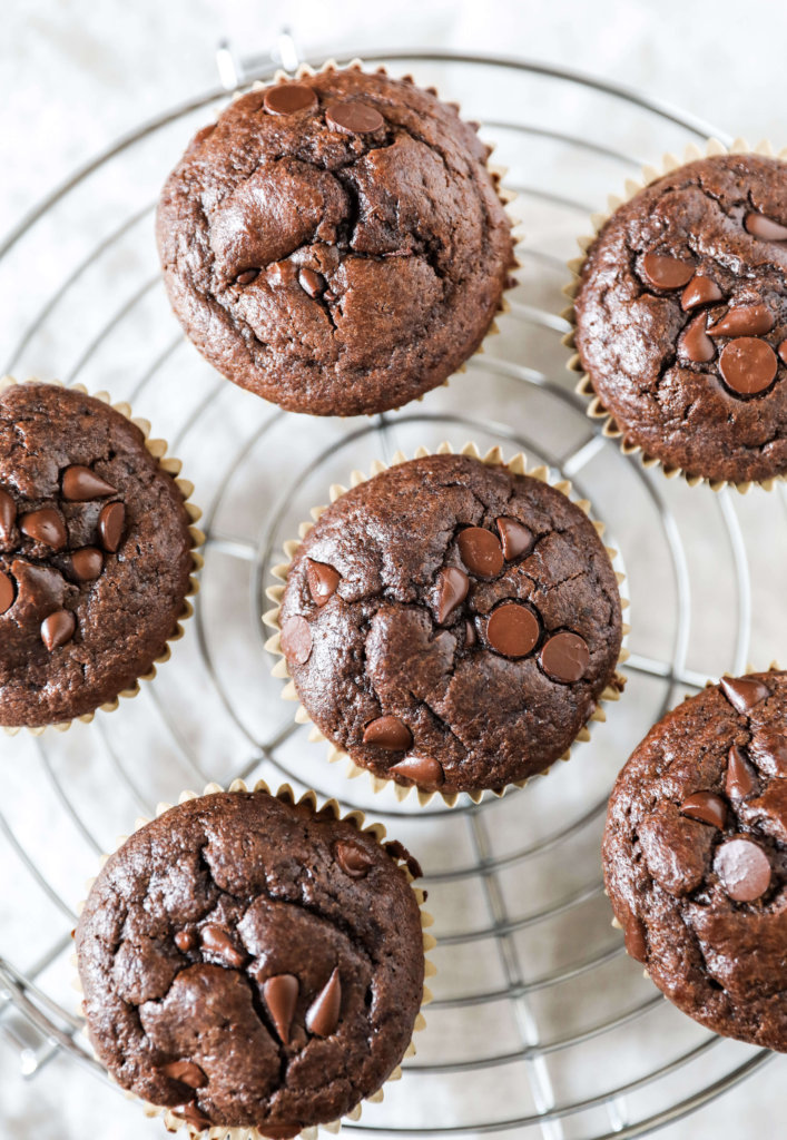 Top down view of double chocolate muffins on a circular cooling rack.