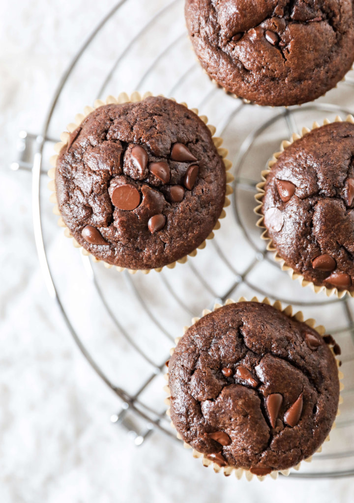 Top down view of some double chocolate muffins on a circular cooling rack.