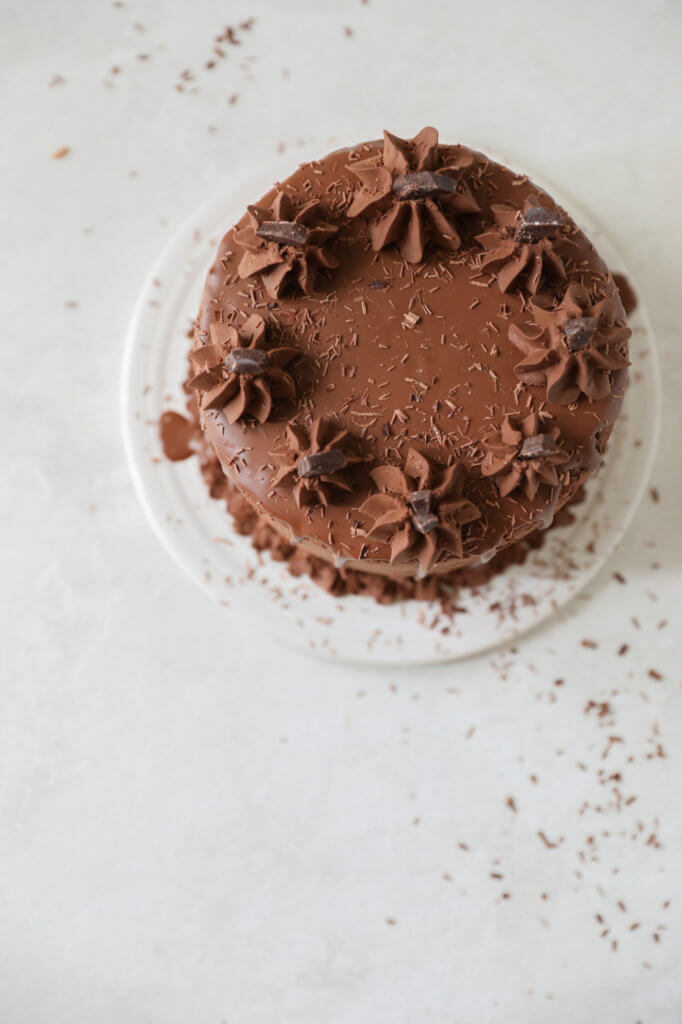 Top down view of chocolate zucchini cake with decorative chocolate frosting.