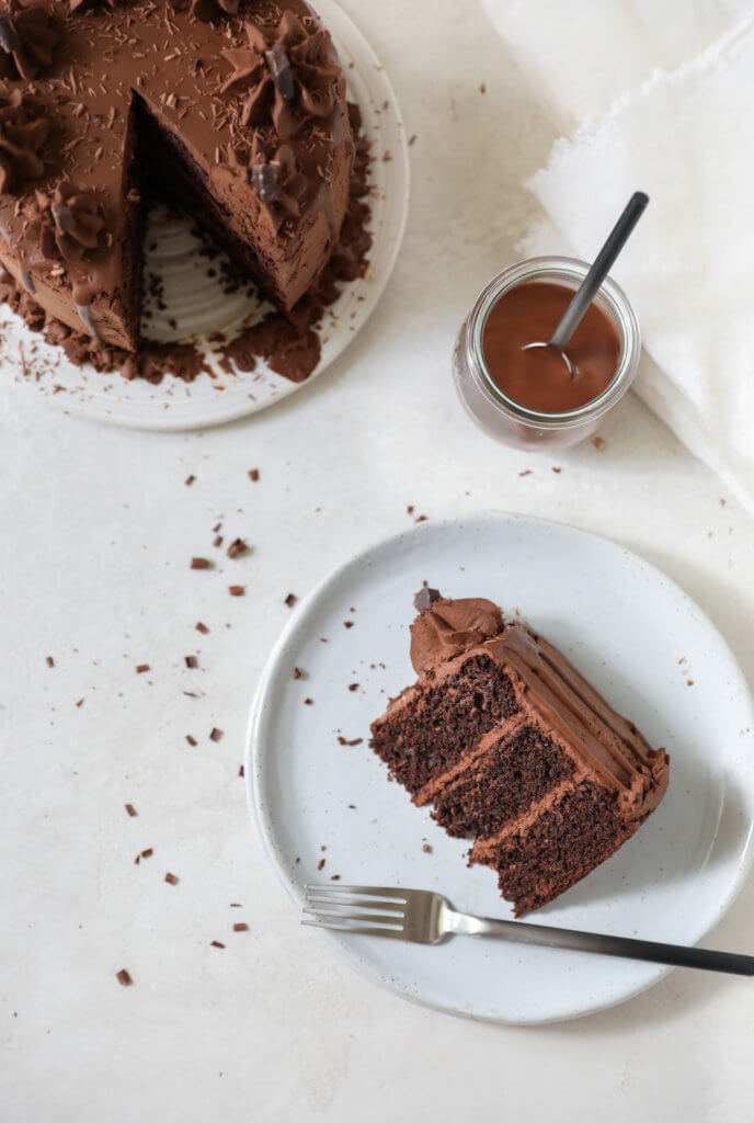 A top down view of chocolate zucchini cake with a piece of chocolate cake on a plate